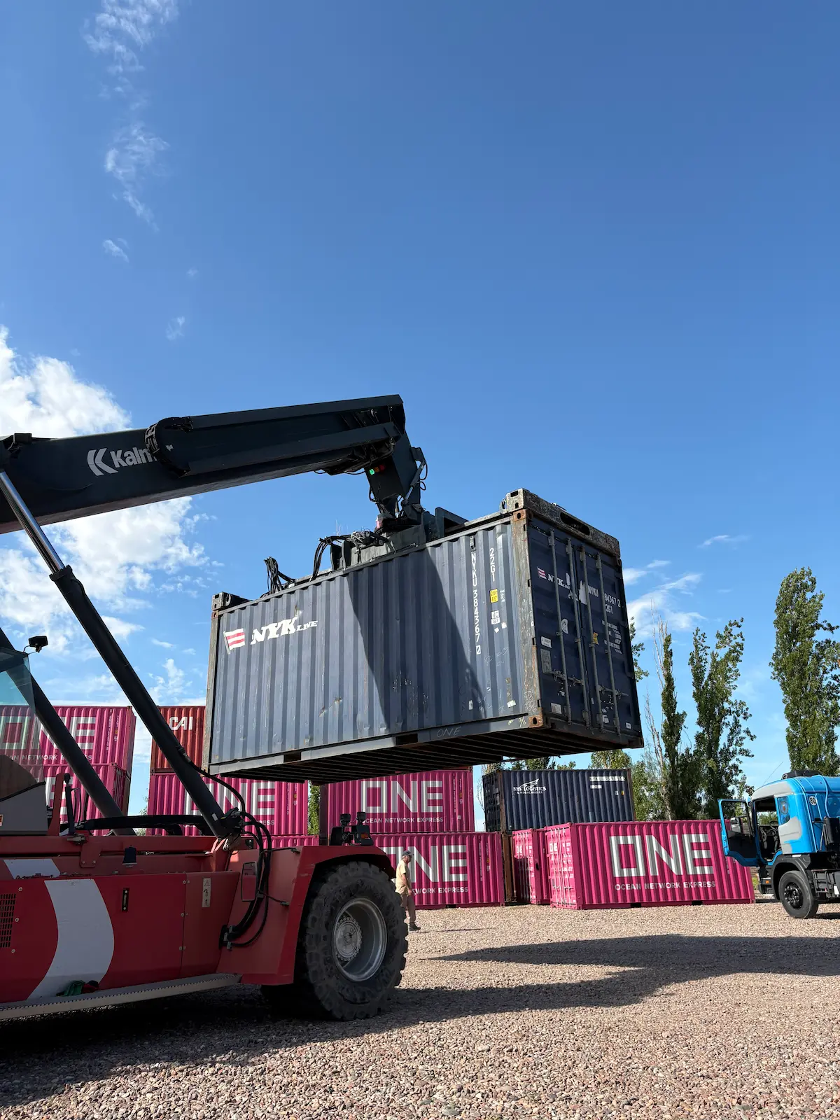 Grúa portuaria trasladando un contenedor en una terminal logística